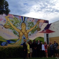 Artist Ruben Ubiera and Tamarac city officials pose for a photo during the unveiling of Ubiera's mural "Lady Justice."
